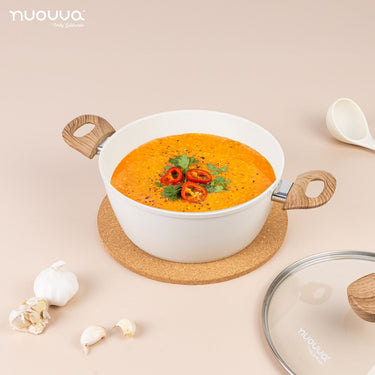 Cream deep stockpot with glass lid and wooden handles for efficient home cooking. 